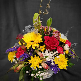 Lilies, yellow gerbera daisies, hot pink roses, pink mini carnations, white daisies, yellow mums, pink alstroemeria and accented with gypsophila, pink wax flowers, purple statice and pussy willow.