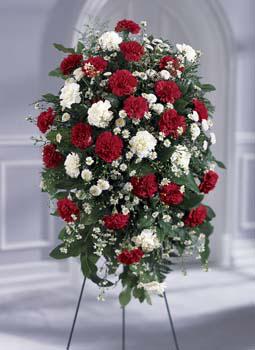 Red & white flowers in a standing spray funeral arrangement for same day delivery to funeral homes in Grand Rapids, MI & worldwide by Sunnyslope Floral